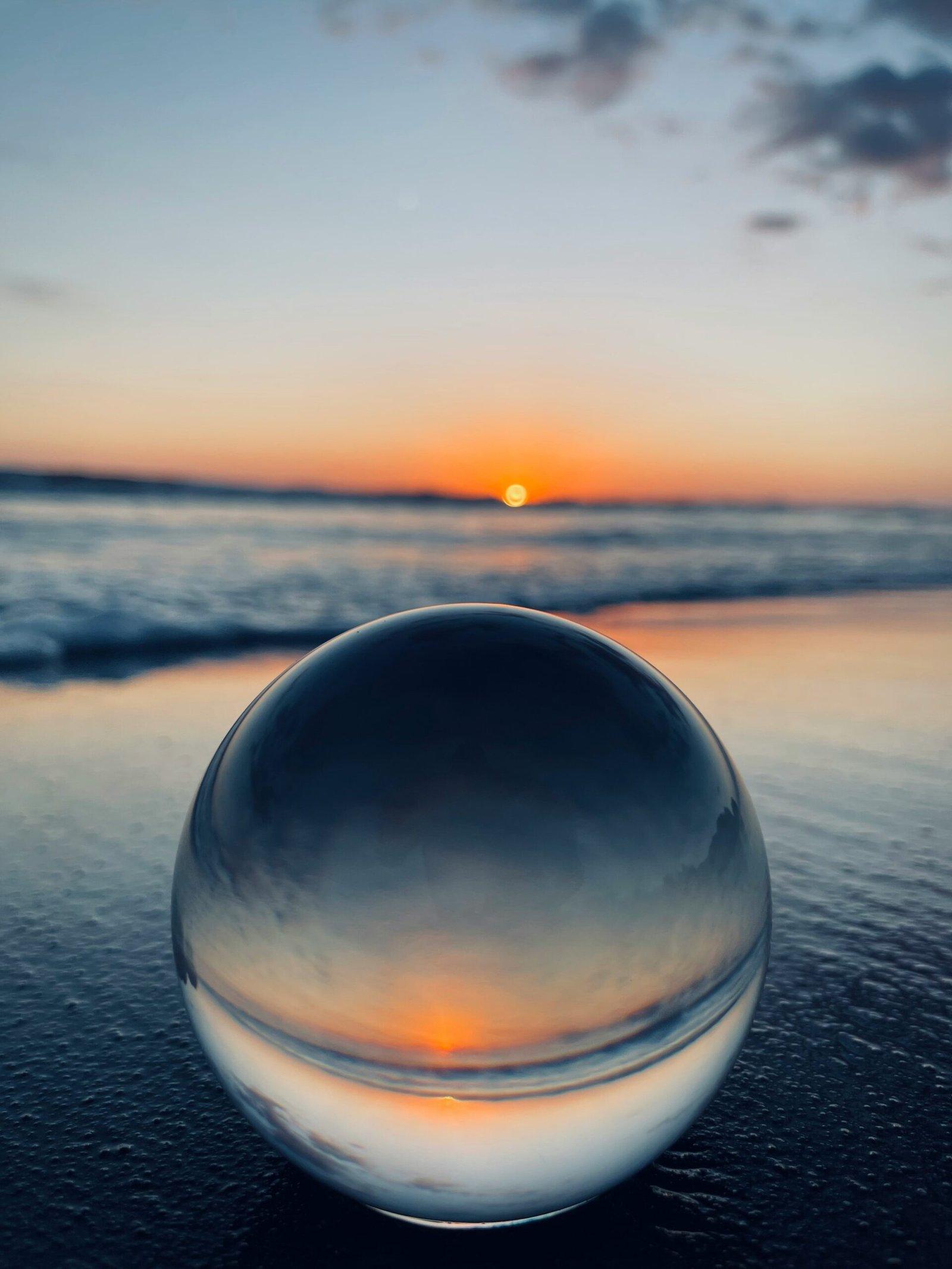 une boule d'eau dans la mer avec un couché de soleil