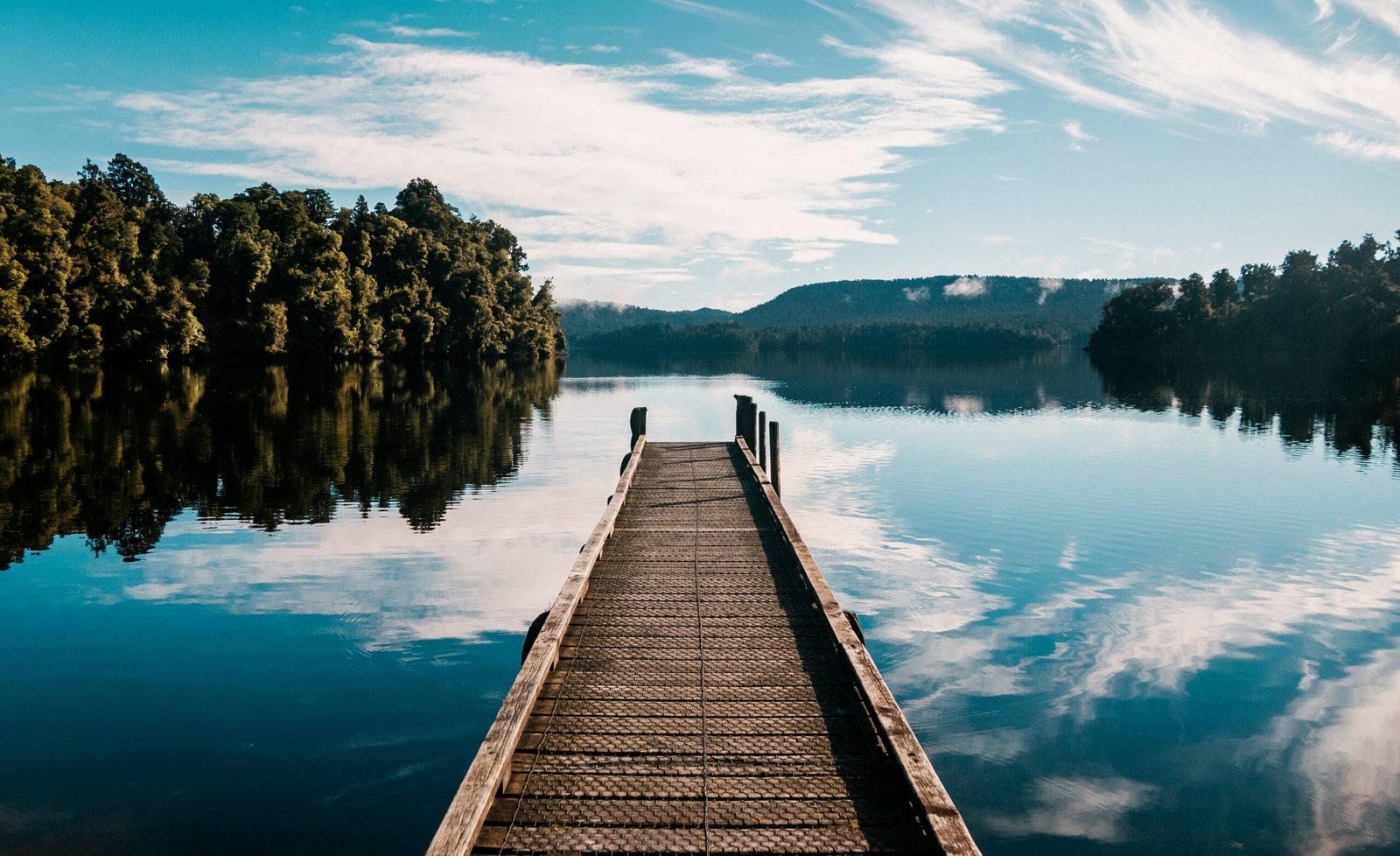 un ponton donnant sur un lac entouré d'arbre