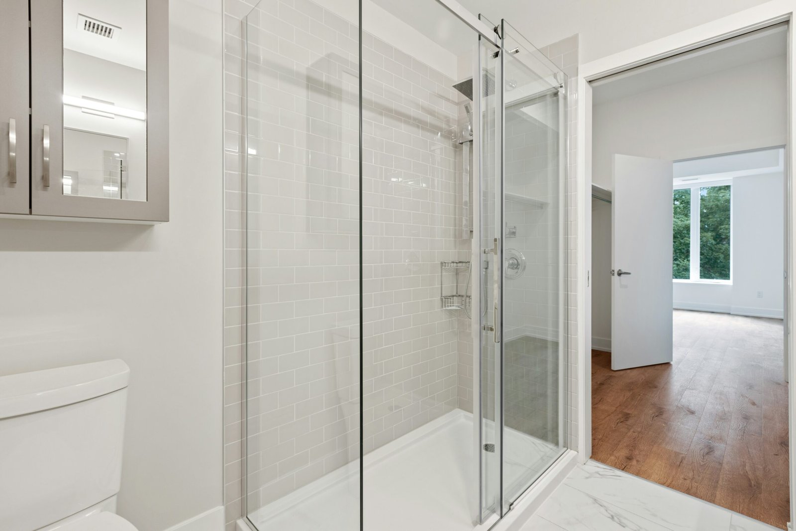 Une belle salle de bains design ouverte sur la chambre avec un receveur antiderapant de 1700 x 800mm avec paroi en verre sur 3 cotés et porte coulissante