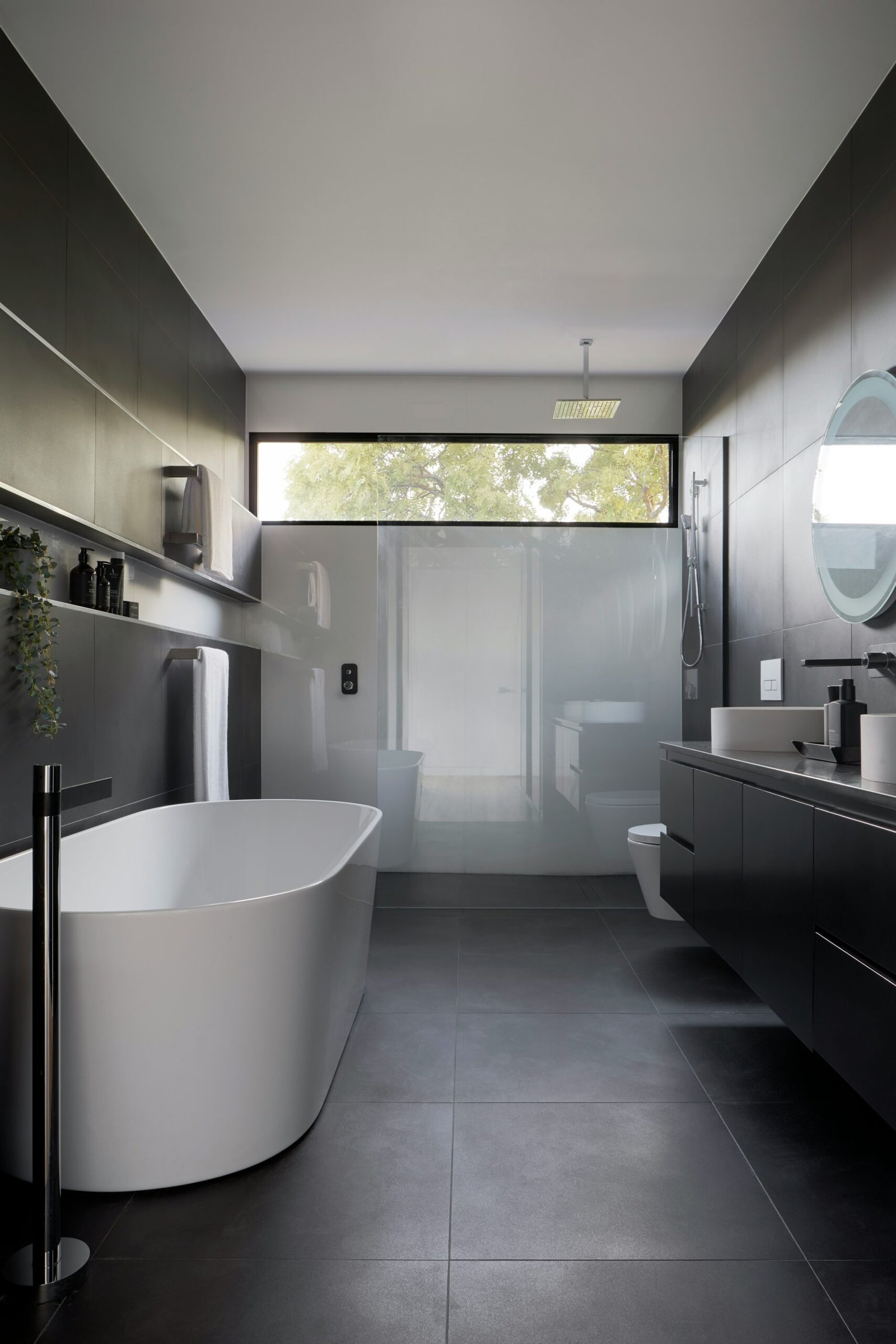 une belle salle de bain design noir et blanche avec baignoire ilot douche italienne un wc suspendu et un meuble double vasque noir Matt
